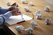 stock photo of business concept  - Tearing up another crumpled paper ball for the pile - JPG 