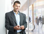 stock photo of businessmen  - Young businessman standing in office lobby - JPG 