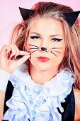 Portrait of a sexy girl in pussycat costume alluring over pink background.