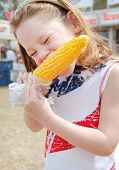 picture of food  - Girl eating corn at fair - JPG 