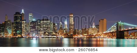 Picture or Photo of New York City Manhattan skyline panorama with Brooklyn Bridge and office skyscrapers building in at dusk illuminated with lights at night