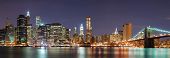 picture of bridge  - New York City Manhattan skyline panorama with Brooklyn Bridge and office skyscrapers building in at dusk illuminated with lights at night - JPG 