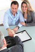 pic of handshake  - Happy couple signing purchase contract with real - JPG 