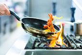 foto of food  - Chef in restaurant kitchen at stove with pan - JPG 