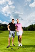 foto of golf  - Young sportive couple playing golf on a golf course - JPG 