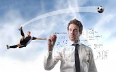 foto of strategy  - Young man writing a soccer strategy with young football player on the background - JPG 