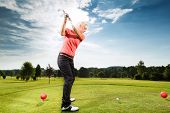 stock photo of golf  - Young female golf player on course doing golf swing - JPG 