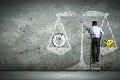 picture of objects  - Businessman on ladder pointing at scale picture - JPG 