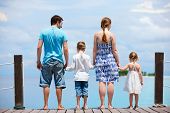 stock photo of family  - Family on wooden dock enjoying ocean view - JPG 