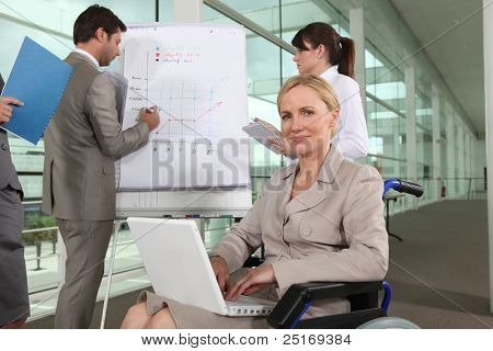 Picture or Photo of Businesswoman sitting in a wheelchair during a presentation