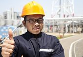 foto of industrial  - chemical industrial engineer with thumbs up and large oil refinery background - JPG 