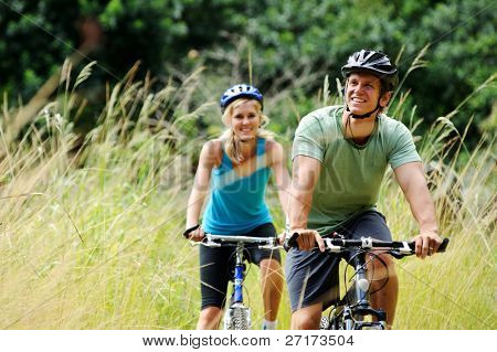 Picture or Photo of Happy couple riding bicycles outside, healthy lifestyle fun concept