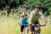 image of fitness  - Happy couple riding bicycles outside - JPG 