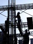stock photo of construction  - construction workers in outline high up on the scaffolding - JPG 