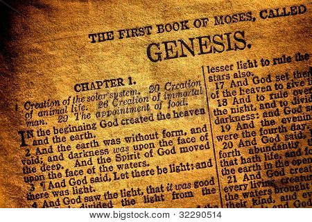 Picture or Photo of Old antique Holy Bible Christian religion book open to the first page of Moses original chapter of genesis and text about god creation of heaven and hearth in the religious Ancient Testament