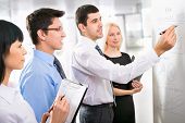 stock photo of group  - Group of business people looking at the graph on flipchart - JPG 