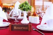 stock photo of restaurant  - Reserved sign on restaurant table with empty dishes and glasses - JPG 