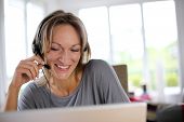 image of helpline  - Portrait of woman with headset in front of laptop - JPG 
