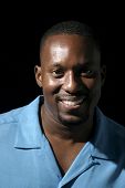 pic of africanamerican  - Low key portrait headshot on black background of a handsome smiling African American male - JPG 