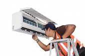 image of fix  - Young repairman fixing a ductless minisplit air conditioning system - JPG 