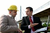 foto of construction worker  - two businessman at workplace before a bridge - JPG 