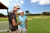 picture of golf  - Couple on golf course with cart - JPG 