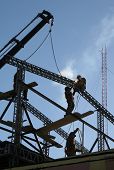 image of construction worker  - Construction site in Ushuaia Argentina with unrecognisable workers welding an iron frame of a building - JPG 