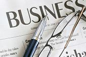 image of newspaper  - Pen and Eyeglasses on Business Headline Newspaper close up - JPG 