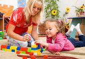image of preschool  - Teacher and child are playing with building bricks in preschool - JPG 