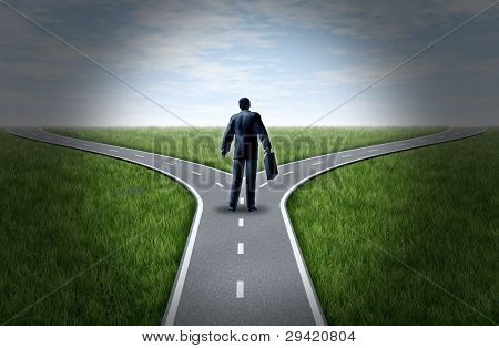 Picture or Photo of Business man at a cross roads standing at a horizon with grass and blue sky showing a fork in the road representing the concept of a strategic dilemma choosing the right direction to go when facing two equal or similar options.