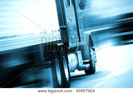 Picture or Photo of Semi Truck in Motion. Semi Track Speeding on the American Highway. Motion Blurred. Blue Tones. Transportation and Spedition Photo Collection.