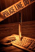 stock photo of dead-line  - Gruesome forensic criminal violent murder crime scene with dead victim woman hand and knife weapon evidence planted into a computer keyboard with blood splatter under police line CSI tape in rough grunge sepia - JPG 