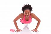 stock photo of fitness  - Young beautiful african fitness woman doing push up exercises on floorisolated on white background - JPG 