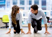 foto of competition  - Competitive business couple ready for a race at the office - JPG 