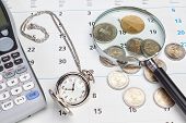 foto of watch  - Business calendar pocket watch magnifier and money on a calendar - JPG 
