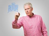 image of buildings  - Mature Man Drawing Buildings On Glass - JPG 