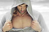 image of fitness  - Sexy man in hooded activewear revealing his muscular chest - JPG 