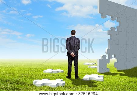 Picture or Photo of Businessman with a puzzle pieces on the background