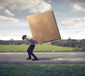 stock photo of man  - Man carrying on his shoulders a large box - JPG 