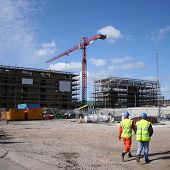 foto of construction worker  - construction workers walking near building site with crane - JPG 