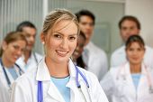 picture of medical doctors  - female doctor smiling in a hospital with her team behind - JPG 