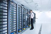 pic of isp  - young engeneer business man with thin modern aluminium laptop in network server room - JPG 