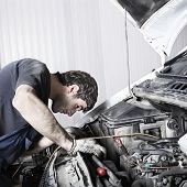 stock photo of tint  - auto mechanic repairing a car engine - JPG 