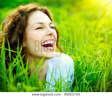 Picture or Photo of Beautiful Young Woman Outdoors. Enjoy Nature. Healthy Smiling Girl in Green Grass.