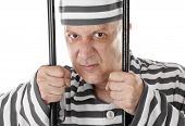 stock photo of lag  - Angry convict prisoner jailbird behind bars - JPG 