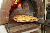 picture of restaurant  - Gourmet Pizza coming out of wood fired Pizza Oven in restaurant - JPG 