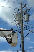 picture of conglomerate  - Electric serviceman works on a conglomeration of wires near voltage boxes on a telephone pole - JPG 