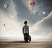 stock photo of future  - Young hopeful businessman searching for his future - JPG 