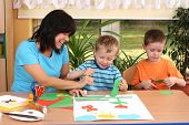 stock photo of preschool  - teacher and two preschoolers making some decoration - JPG 
