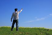 image of blue sky  - Young man pointing with his finger to the blue sky - JPG 